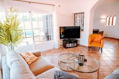 a living room with a couch and a glass table at Villa Angélica - Cozy Homestay in Albufeira