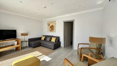 a living room with a couch and a tv at Hibisco 1 by Check-in Portugal in Albufeira