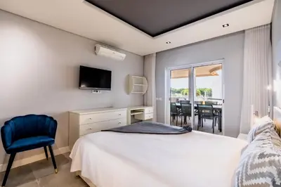a bedroom with a bed and a tv and a chair at Varandas do Sol by Garvetur in Vilamoura