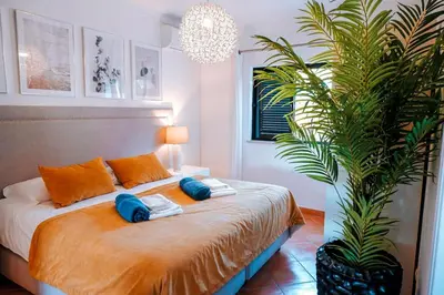 a bedroom with a bed with two pillows and a palm tree at Villa Miracampo - Elegant Secret in Albufeira