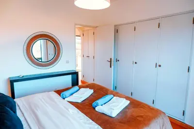 a bedroom with a bed with two blue pillows on it at Villa Miracampo - Elegant Secret in Albufeira