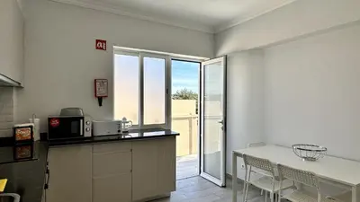 a kitchen with a counter and a table with chairs at Hibisco 2 by Check-in Portugal in Albufeira