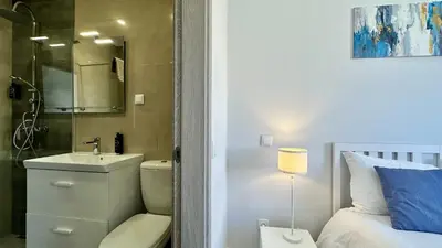 a bathroom with a sink and a toilet next to a bed at Hibisco 2 by Check-in Portugal in Albufeira