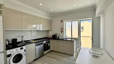a kitchen with a washing machine and a table at Hibisco 2 by Check-in Portugal in Albufeira