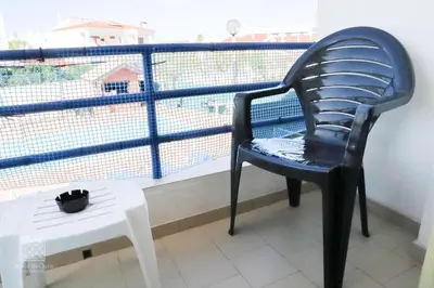 a black chair sitting on a balcony next to a white table at Apartamentos Sereia da Oura in Albufeira