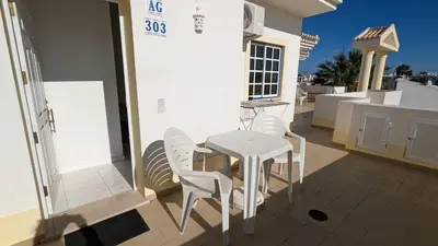 a white table and chairs on a patio at Apartamentos Sereia da Oura in Albufeira