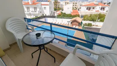 a balcony with a table and a view of a pool at Apartamentos Sereia da Oura in Albufeira