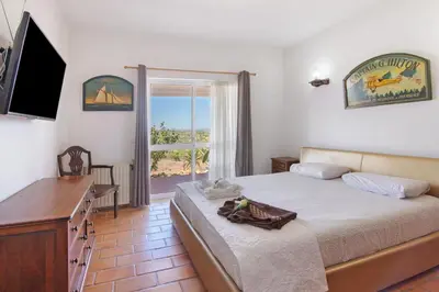 a bedroom with a bed and a flat screen tv at Monte do Pataco in Albufeira