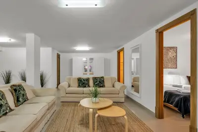 a living room with two couches and a table at Extraordinary Villa on an elevated position in Quinta do Lago in Quinta do Lago
