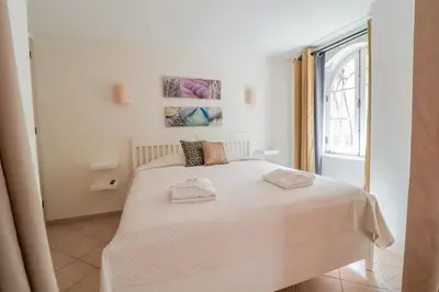a bedroom with a white bed with two towels on it at Old Village Vilamoura in Quarteira