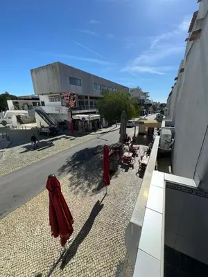 a street with chairs and umbrellas on the side of a building at Flat Luxuous Praia da Oura in Albufeira