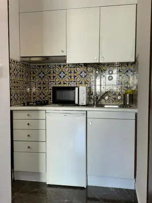 a kitchen with white cabinets and a microwave at Flat Luxuous Praia da Oura in Albufeira