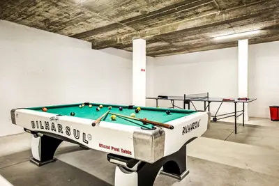 a ping pong table in a room with a pool at Villa Aventura in Albufeira
