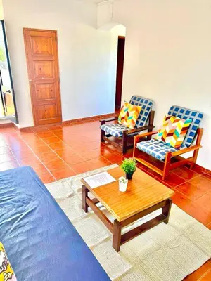 a living room with two chairs and a coffee table at Resort Albufeira T1, Praia da Oura in Albufeira