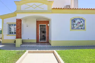 a small white house with a door and a window at Villa Vivienda Rosa in Albufeira