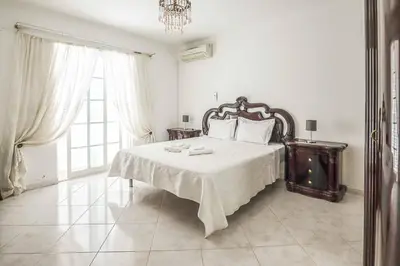 a bedroom with a bed and a chandelier at Villa Vivienda Rosa in Albufeira