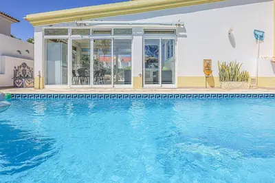 a swimming pool in front of a house at Villa Vivienda Rosa in Albufeira
