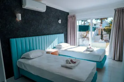 two beds in a hotel room with a window at Villa Coelha - Algarve's Pearl in Albufeira