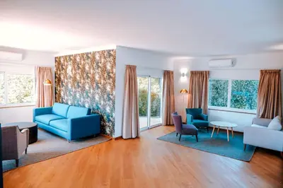 a living room with blue furniture and a painting at Villa Coelha - Algarve's Pearl in Albufeira