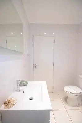 a white bathroom with a toilet and a sink at Villa dos Sonhos - Wide Dreams in Albufeira