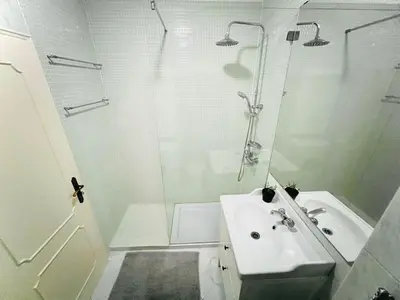 a white bathroom with a shower and a sink at Apartamento 5 Estrelas Praia da Oura in Albufeira