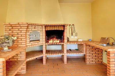 a brick fireplace in a kitchen with a sink at Villa Lisianto in Albufeira