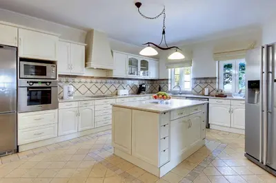 a large kitchen with white cabinets and appliances at Villa Lisianto in Albufeira