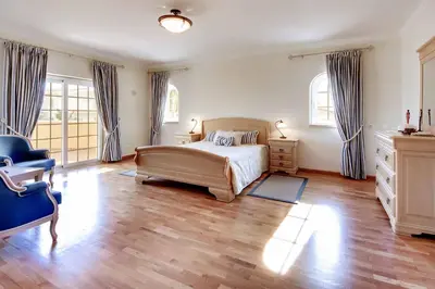a bedroom with a bed and a blue chair at Villa Lisianto in Albufeira