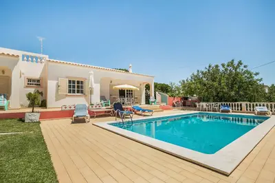 a villa with a swimming pool in front of a house at Villa Cerrinho in Albufeira