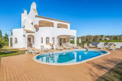 a villa with a swimming pool in front of a house at Villa Natalia Sun in Albufeira