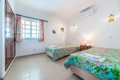 a bedroom with a bed and a toilet and a mirror at Villa Natalia Sun in Albufeira