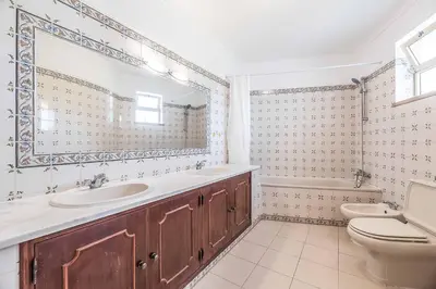 a white bathroom with a toilet and a sink at Villa Natalia Sun in Albufeira