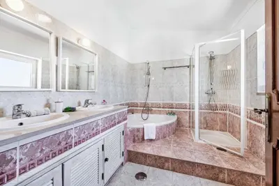 a bathroom with two sinks and a shower and a tub at Villa Tilia in Galé