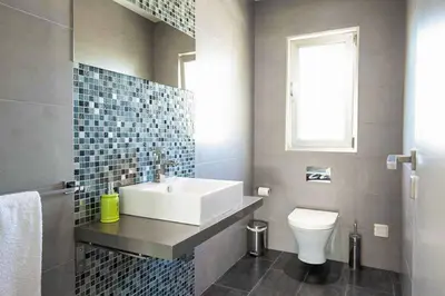 a bathroom with a sink and a toilet and a window at Villa Dala in Albufeira