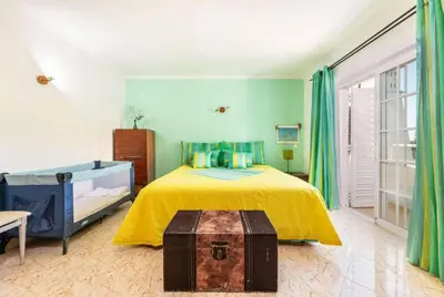 a bedroom with a bed with a yellow bedspread at Casa Oliveira in Albufeira