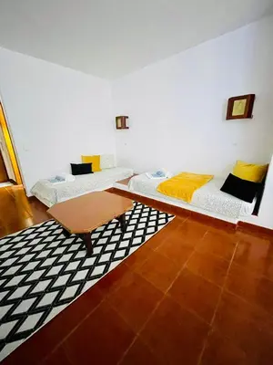 a room with two beds and a table in it at Resort Albufeira T1, Praia da Oura in Albufeira