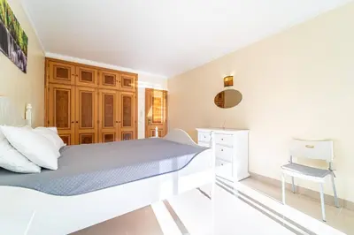 a white bedroom with a bed and a desk at Blue Horizon Apartment by HelloVacations in Albufeira