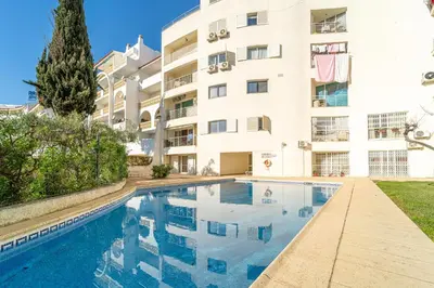 a swimming pool in front of a building at Blue Horizon Apartment by HelloVacations in Albufeira