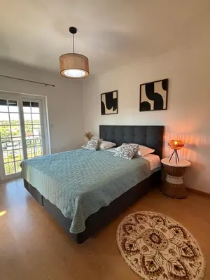 a bedroom with a bed with a blue comforter at Invited to Albufeira in Guia