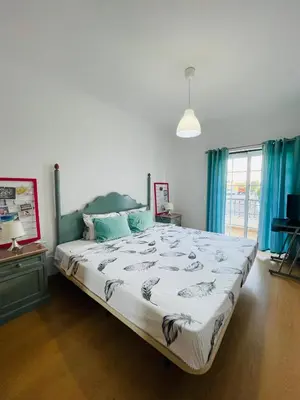 a bedroom with a large bed with blue curtains at Invited to Albufeira in Guia