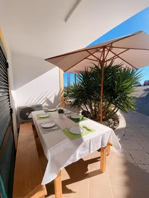 a table with a white table cloth and an umbrella at Invited to Albufeira in Guia