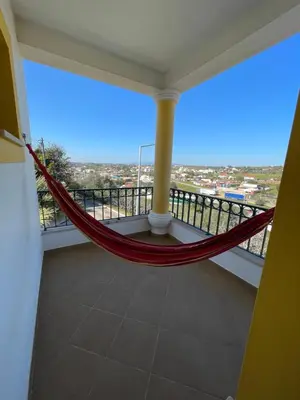 a hammock on a balcony with a view at Invited to Albufeira in Guia