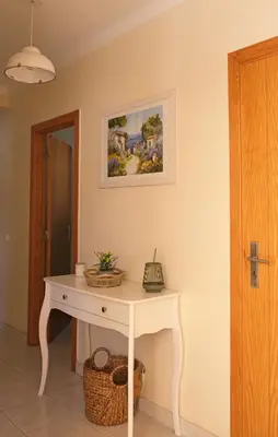 a white table in a room with a picture on the wall at Jardins da Falesia in Albufeira