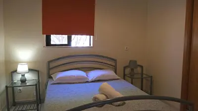 a bedroom with a bed with two tables and a window at Jardins da Falesia in Albufeira