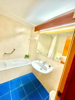 a bathroom with a white tub and a sink at Resort Albufeira T1, Praia da Oura in Albufeira