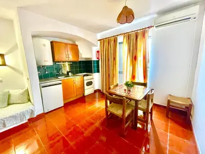 a kitchen with a table and a dining room at Resort Albufeira T1, Praia da Oura in Albufeira