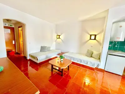 a room with two beds and a table in it at Resort Albufeira T1, Praia da Oura in Albufeira