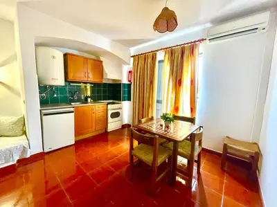 a kitchen with a table and a kitchen with green at Resort Albufeira T1, Praia da Oura in Albufeira