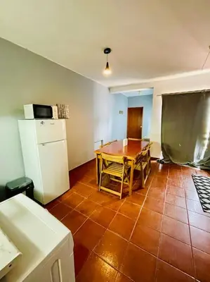 a kitchen with a table and a white refrigerator at Resort Albufeira T2, Praia da Oura in Albufeira