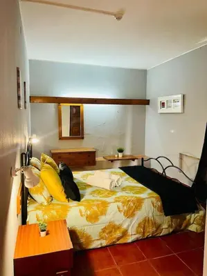 a bedroom with a bed with yellow pillows at Resort Albufeira T2, Praia da Oura in Albufeira